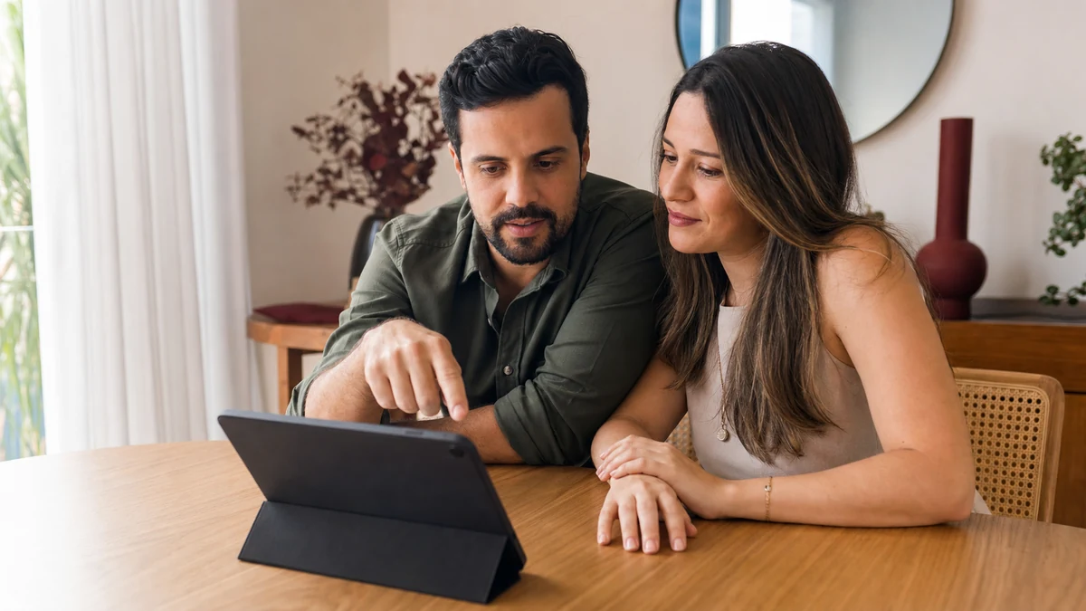 Casal revisando em conjunto no tablet as próximas decisões do casamento